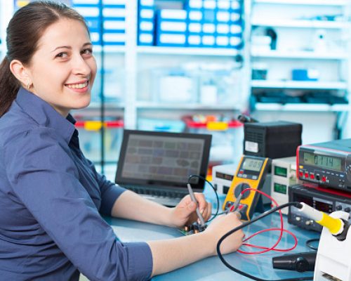 Woman with a tester and a printed circuit board